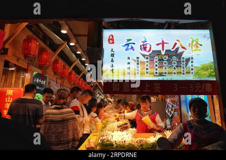 (190811) -- DALI, 11 agosto 2019 -- i turisti acquistano cibo locale nella città vecchia di Dali, nella provincia dello Yunnan della Cina sud-occidentale, 10 agosto 2019. I turisti sono venuti qui per godere di un'incantevole vista notturna, del cibo locale e di spettacoli attraenti durante le ore notturne. CHINA-YUNNAN-DALI-NIGHT VIEW (CN) QINXQING PUBLICATIONXNOTXINXCHN Foto Stock