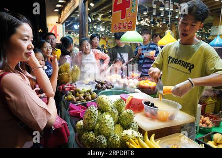 (190811) -- DALI, 11 agosto 2019 -- i turisti acquistano frutta assortita nella città vecchia di Dali, nella provincia dello Yunnan della Cina sud-occidentale, 10 agosto 2019. I turisti sono venuti qui per godere di un'incantevole vista notturna, del cibo locale e di spettacoli attraenti durante le ore notturne. CHINA-YUNNAN-DALI-NIGHT VIEW (CN) QINXQING PUBLICATIONXNOTXINXCHN Foto Stock