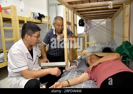 (190812) -- SHOUGUANG, 12 agosto 2019 -- Un residente riceve cure mediche in una scuola media, che ora funge da sito di trasferimento, a Shouguang, nella provincia di Shandong nella Cina orientale, 12 agosto 2019. Circa 93.000 residenti locali sono stati trasferiti quando il tifone Lekima ha causato il caos in alcune parti di Shouguang. CHINA-SHANDONG-TYPHOON-LEKIMA-RELOCATION (CN) GUOXXULEI PUBLICATIONXNOTXINXCHN Foto Stock