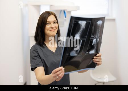 Il medico esamina una radiografia della colonna cervicale Foto Stock