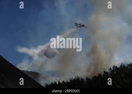 (190815) -- ATENE, 15 agosto 2019 (Xinhua) -- un aereo spruzza su un fronte di fuoco attivo vicino al villaggio di Stavros, sull'isola di Evia, Grecia, il 14 agosto 2019. Tra gli sforzi in corso per spegnere un incendio distruttivo, mercoledì il primo ministro greco Kyriakos Mitsotakis ha chiesto una maggiore cooperazione tra i membri dell'Unione europea (UE) per affrontare le future catastrofi naturali. Ha fatto la chiamata durante una visita all'isola di Evia colpita dal fuoco. Alimentati da forti venti, le fiamme minacciavano i villaggi a circa 80 chilometri a nord-est di Atene, costringendo l'evacuazione di centinaia di residenti il martedì. (Foto di NIC Foto Stock