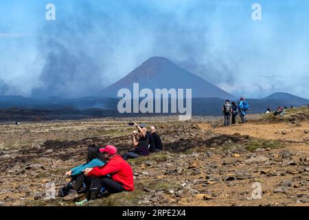 Grindavik, Islanda-28 luglio 2023; persone che osservano fessure vicino alla collina di Litli-Hrútur durante l'eruzione del 2023 vicino alla montagna Fagradalsfjall con la moun subglaciale Foto Stock