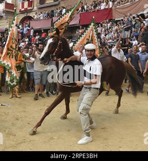 (190817) -- SIENA, 17 agosto 2019 (Xinhua) -- i membri della Selva (quartiere forestale) festeggiano dopo che il loro cavallo Remorex ha vinto il Palio senza il suo fantino a Siena, in Italia, 16 agosto 2019. La tradizionale corsa di cavalli Palio si svolge ogni luglio e agosto nella storica città italiana di Siena. (Foto di Alberto Lingria/Xinhua) (SP)ITALIA-SIENA-IPPODROMO-PALIO PUBLICATIONxNOTxINxCHN Foto Stock