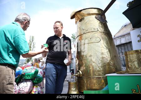 (190817) -- SARAJEVO, 17 agosto 2019 -- Un uomo consegna una tazza di caffè a un uomo anziano sulla piazza Bascarsija a Sarajevo, Bosnia-Erzegovina (BiH), 17 agosto 2019. La gente ha avuto l'opportunità qui il sabato di assaggiare il vero caffè bosniaco da questa grande dzezva (caffettiera). (Foto di /Xinhua) BOSNIA ED ERZEGOVINA-SARAJEVO-BIGGEST COFFEE POT NedimxGrabovica PUBLICATIONxNOTxINxCHN Foto Stock