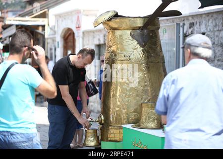 (190817) -- SARAJEVO, 17 agosto 2019 -- Un uomo prepara un caffè sulla piazza Bascarsija a Sarajevo, Bosnia-Erzegovina (BiH), 17 agosto 2019. La gente ha avuto l'opportunità qui il sabato di assaggiare il vero caffè bosniaco da questa grande dzezva (caffettiera). (Foto di /Xinhua) BOSNIA ED ERZEGOVINA-SARAJEVO-BIGGEST COFFEE POT NedimxGrabovica PUBLICATIONxNOTxINxCHN Foto Stock