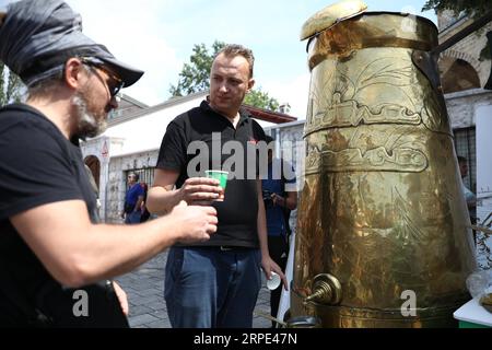 (190817) -- SARAJEVO, 17 agosto 2019 -- Un uomo consegna una tazza di caffè a un uomo anziano sulla piazza Bascarsija a Sarajevo, Bosnia-Erzegovina (BiH), 17 agosto 2019. La gente ha avuto l'opportunità qui il sabato di assaggiare il vero caffè bosniaco da questa grande dzezva (caffettiera). (Foto di /Xinhua) BOSNIA ED ERZEGOVINA-SARAJEVO-BIGGEST COFFEE POT NedimxGrabovica PUBLICATIONxNOTxINxCHN Foto Stock