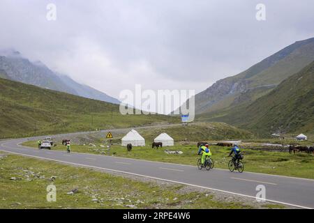 (190818) -- URUMQI, 18 agosto 2019 -- gli appassionati di ciclismo cavalcano sull'autostrada Dushanzi-Kuqa, regione autonoma dello Xinjiang Uygur della Cina nord-occidentale, 17 agosto 2019. La sezione Dushanzi-Kuqa della National Highway 217 attraversa vari paesaggi naturali, tra cui ghiacciai, laghi, foreste e praterie, che lo rendono un popolare percorso di viaggio tra viaggiatori che viaggiano da soli, appassionati di ciclismo e escursionisti. ) CHINA-XINJIANG-DUSHANZI-KUPA HIGHWAY-SCENIC (CN) LIXPENG PUBLICATIONXNOTXINXCHN Foto Stock