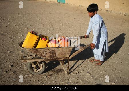 (190818) -- JALALABAD, 18 agosto 2019 (Xinhua) -- un bambino afghano trasporta barili dopo aver prelevato acqua da una pompa dell'acqua pubblica in un campo sfollato nel distretto di Rodat a Nangarhar, Afghanistan, 17 agosto 2019. (Foto di Saifurahman Safi/Xinhua) AFGHANISTAN-NANGARHAR-PUBLIC WATER PUBLICATIONxNOTxINxCHN Foto Stock