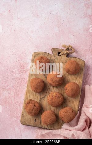 Tartufi al cioccolato ricoperti di cacao in polvere. Sfondo rosa. Tabella vista dall'alto. Deliziose caramelle, gustoso dessert. Foto Stock