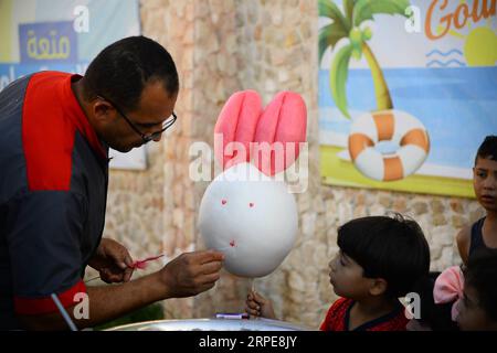 (190821) -- GAZA, 21 agosto 2019 (Xinhua) -- Mohammed al-Wakeel, un palestinese di 33 anni che è bravo a progettare caramelle di cotone in varie forme e colori, produce caramelle di cotone in un parco nella città di Gaza, 19 agosto 2019. (Str/Xinhua) MIDEAST-GAZA-DAILY LIFE-COTTON CANDY PUBLICATIONxNOTxINxCHN Foto Stock