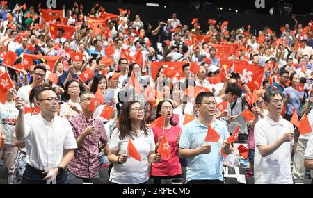 (190825) -- HONG KONG, 25 agosto 2019 -- bandiere delle persone ondeggiano durante un evento organizzato nell'Ocean Park dall'Hong Kong Chinese Enterprises Association per unire le famiglie nelle loro richieste di ordine e armonia a Hong Kong, 24 agosto 2019. ) CHINA-HONG KONG-FAMILIES-EVENT(CN) LUXHANXIN PUBLICATIONXNOTXINXCHN Foto Stock