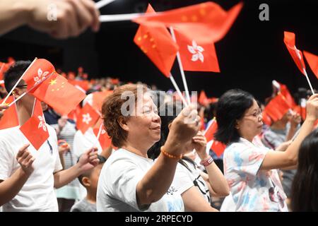 (190825) -- HONG KONG, 25 agosto 2019 -- bandiere delle persone ondeggiano durante un evento organizzato nell'Ocean Park dall'Hong Kong Chinese Enterprises Association per unire le famiglie nelle loro richieste di ordine e armonia a Hong Kong, 24 agosto 2019. ) CHINA-HONG KONG-FAMILIES-EVENT(CN) LUXHANXIN PUBLICATIONXNOTXINXCHN Foto Stock