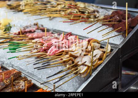 Molti spuntini crudi e frutti di mare nello Street food di Jalan Alor a Kuala Lumpur Foto Stock