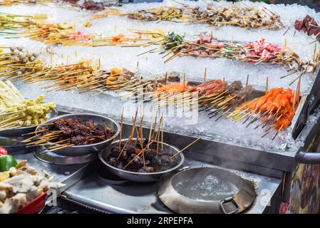 Molti spuntini crudi e frutti di mare nello Street food di Jalan Alor a Kuala Lumpur Foto Stock