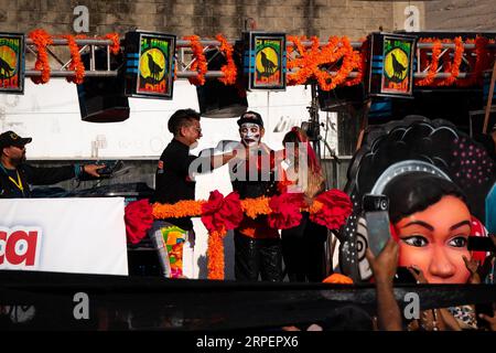 Barranquilla, Atlantico, Colombia - 18 febbraio 2023: A Man with His Face Painted White punta alla folla da un Float Foto Stock