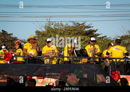 Barranquilla, Atlantico, Colombia - 18 febbraio 2023: Uomini vestiti di giallo canta e suona musica alla sfilata di Carnevale Foto Stock