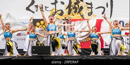 Squadra di danza giapponese Yosakoi con costumi d'argento e blu su un palco all'aperto che balla all'annuale festival Kumamoto Kyusyu Gassai. Foto Stock