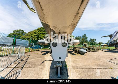 Grandangolo basso, carro anteriore di un aereo da caccia RAF SEPECAT Jaguar GR3 in mostra all'aperto presso il RAF Manston History Museum in una giornata di sole. Foto Stock