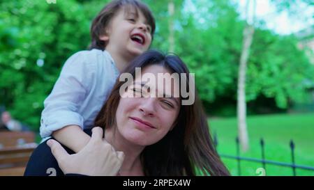 Un ragazzino incauto che soffoca la mamma mentre gioca. Il ragazzo non conosce i limiti del gioco, la madre sconvolta, la vita reale Foto Stock