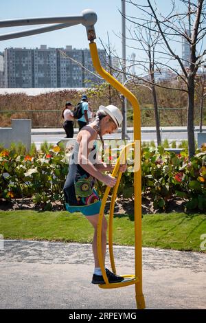 Una donna bianca più anziana che gioca in un parco pubblico Foto Stock