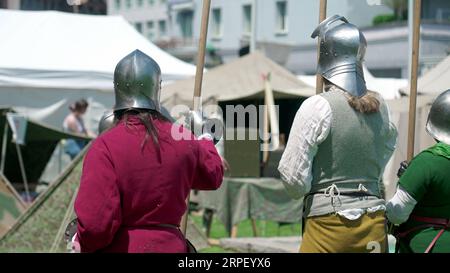 Guardiani del passato, soldati pronti con Spears alla Reenactment Festiva. Soldati con caschi d'acciaio alla Fiera storica di Standby Foto Stock