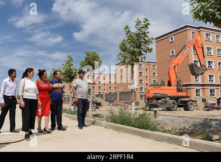 (190910) -- KASHGAR, 10 settembre 2019 -- Helipat (2nd R) e sua moglie (3rd R) visitano la loro nuova casa in un sito di trasferimento nella contea di Yecheng a Kashgar, nella regione autonoma di Xinjiang Uygur della Cina nord-occidentale, 19 agosto 2019. Grazie ai progetti di delocalizzazione delle politiche di riduzione della povertà, la famiglia Helipat si trasferirà presto nella sua nuova casa nella contea. Per adempiere alla missione di sradicare la povertà assoluta entro il 2020, lo Xinjiang ha aiutato gli agricoltori e i pastori impoveriti a trasferirsi dalle regioni montuose e dall'entroterra desertico per reinsediarsi nelle pianure e nelle oasi. Alla fine del 2018, un totale di 140.000 Foto Stock