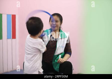 (190911) -- CHONGQING, 11 settembre 2019 -- insegnante di educazione speciale ha gestito Xianxi gioca con un bambino al Chongqing Hyacinth Rehabilitation and Training Center nel sud-ovest della Cina, nel comune di Chongqing, 10 settembre 2019. Nati negli anni '1990, un insegnante speciale di educazione ha gestito Xianxi e Wang Huajun ha trascorso il loro primo Teachers Day al Chongqing Hyacinth Rehabilitation and Training Center martedì, dopo aver lasciato il lavoro ben pagato in altre istituzioni di formazione due mesi fa. Combinando il loro background professionale di psicologia applicata e devozione, il loro duro lavoro è stato molto apprezzato dal loro colle Foto Stock