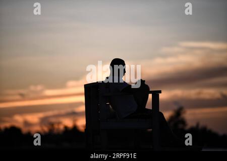 (190917) -- NASSAU, 17 settembre 2019 -- Un uomo gode del tramonto sulla spiaggia giorni dopo l'uragano Dorian che ha travolto Nassau, capitale delle Bahamas, 16 settembre 2019. L'uragano Dorian, una tempesta di categoria 5, è approdato a Elbow Cay nelle Isole Abaco nelle Bahamas il 1 settembre. Secondo i media, l'elenco dei dispersi a seguito dell'uragano Dorian ammonta a 1.300 persone allarmanti e il bilancio delle vittime è di 50. ) BAHAMAS-NASSAU-HURRICANE DORIAN XinxYuewei PUBLICATIONxNOTxINxCHN Foto Stock