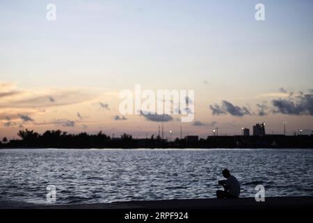 (190917) -- NASSAU, 17 settembre 2019 -- Un uomo gode del tramonto sulla spiaggia giorni dopo l'uragano Dorian che ha travolto Nassau, capitale delle Bahamas, 16 settembre 2019. L'uragano Dorian, una tempesta di categoria 5, è approdato a Elbow Cay nelle Isole Abaco nelle Bahamas il 1 settembre. Secondo i media, l'elenco dei dispersi a seguito dell'uragano Dorian ammonta a 1.300 persone allarmanti e il bilancio delle vittime è di 50. ) BAHAMAS-NASSAU-HURRICANE DORIAN XinxYuewei PUBLICATIONxNOTxINxCHN Foto Stock