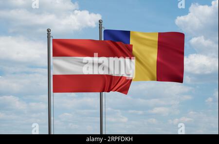 Romania e Austria sventolano insieme nel vento sul cielo blu, concetto di cooperazione tra due paesi Foto Stock