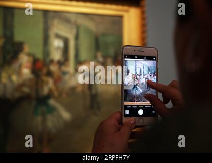 190924 -- PARIGI, 24 settembre 2019 -- Un visitatore scatta una foto di un dipinto durante la mostra Degas at the Opera at the Orsay Museum a Parigi, Francia, 24 settembre 2019. La mostra durerà fino al 19 gennaio 2020. FRANCE-PARIS-ORSAY MUSEUM-EXHIBITION GaoxJing PUBLICATIONxNOTxINxCHN Foto Stock