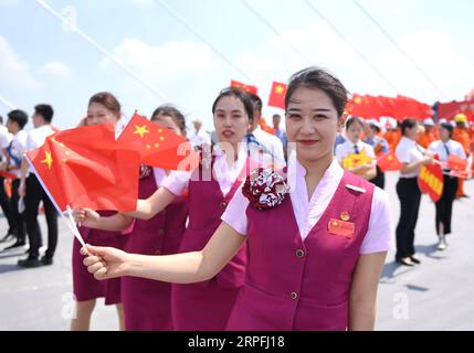 190925 -- FUZHOU, 25 settembre 2019 -- i membri dello staff del China Railway Nanchang Group partecipano a una cerimonia che segna il completamento della struttura principale del ponte stradale-ferroviario dello stretto di Pingtan nella provincia del Fujian della Cina sudorientale, 25 settembre 2019. La Cina mercoledì ha completato la struttura principale del ponte stradale-ferroviario più lungo del mondo nel Fujian. L'ultima trave in acciaio, del peso di 473 tonnellate, è stata imbullonata sul ponte ferroviario stradale dello stretto di Pingtan, un altro mega progetto in Cina, mercoledì mattina. Con una sbalorditiva estensione di 16,34 km, il ponte collega l'Isola di Pingtan e quattro isolotti vicini alla principale Foto Stock