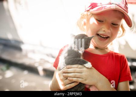 Salvataggio di animali. Un gattino randagio salvato da un bambino Foto Stock