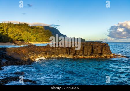 Le rocce e le piscine di Lave presso la spiaggia di Lumaha'i sull'isola hawaiana di Kauai con le montagne di Na Pali alle spalle. Preso all'alba Foto Stock