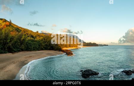 Immagine panoramica aerea al largo della costa sulla spiaggia di Lumaha'i sull'isola hawaiana di Kauai con le montagne di Na Pali alle spalle. Preso all'alba Foto Stock