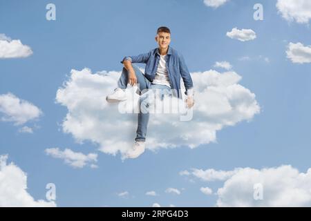 Adolescente maschio che galleggia su una nuvola nel cielo Foto Stock