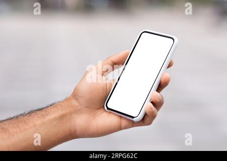 Uomo non riconoscibile che tiene il telefono con la mano con schermo bianco vuoto Foto Stock