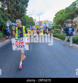 Haifa, Israele - 02 settembre 2023: La gente marcia con vari segni e bandiere, guidati da educatori. Settimana 35 di protesta contro controversa ove giudiziaria Foto Stock