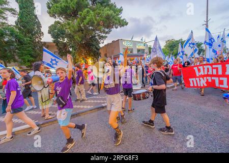 Haifa, Israele - 02 settembre 2023: La gente marcia con vari segni e bandiere. Settimana 35 di protesta contro la controversa revisione giudiziaria. Haifa, Isra Foto Stock