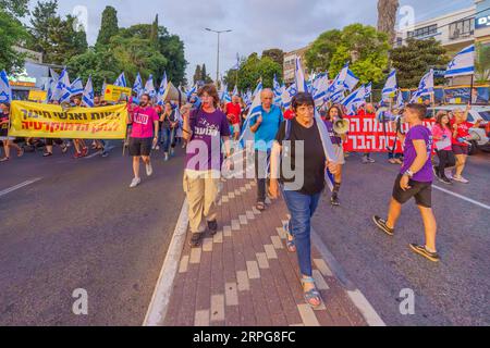 Haifa, Israele - 02 settembre 2023: La gente marcia con vari segni e bandiere. Settimana 35 di protesta contro la controversa revisione giudiziaria. Haifa, Isra Foto Stock