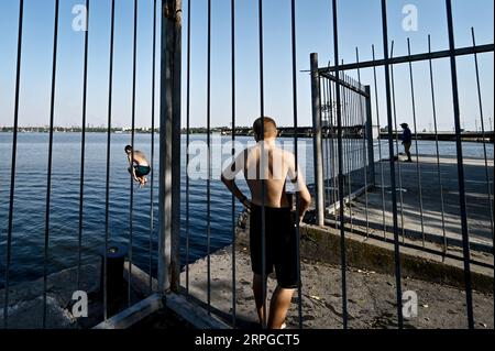Non esclusiva: ZAPORIZHZHIA, UCRAINA - 31 AGOSTO 2023 - Un uomo si tuffa nel fiume Dnipro, Zaporizhzhia, Ucraina meridionale. Foto Stock