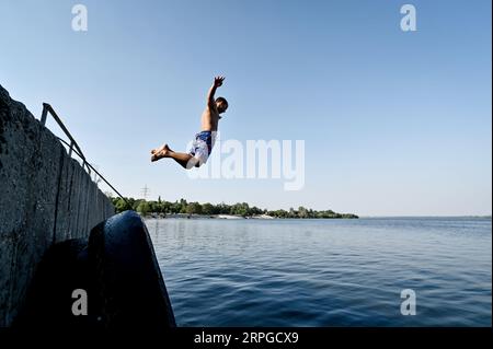 Non esclusiva: ZAPORIZHZHIA, UCRAINA - 31 AGOSTO 2023 - Un uomo si tuffa nel fiume Dnipro, Zaporizhzhia, Ucraina meridionale. Foto Stock
