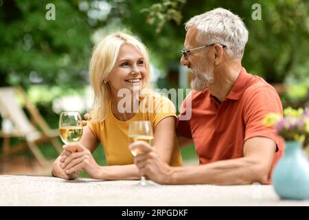 Ritratto di Loving sposata coppia anziana che beve vino all'aperto Foto Stock