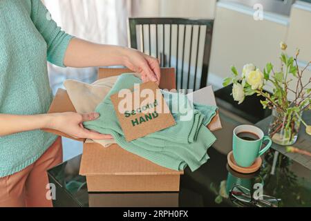 Donna imballaggio scatola con abiti usati per la rivendita Foto Stock