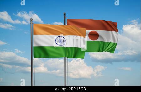 Bandiera del Niger e bandiera dell'India che sventolano insieme sul cielo blu, concetto di cooperazione tra due paesi Foto Stock