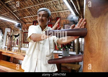 191101 -- HANOI, 1 novembre 2019 -- il maestro vietnamita Wing Chun Tran Viet Trung dimostra tecniche battendo un manichino di legno ad Hanoi, capitale del Vietnam, 25 agosto 2019. Seduto in un'accogliente stanza piena di libri, erboristeria e rimedi freddi nella tranquilla periferia della capitale del Vietnam Hanoi è un uomo d'affari dai capelli grigi che ha creato una nuova scuola di Wing Chun, pazienti curati basati sulle arti marziali cinesi e la medicina, e ha scritto libri più venduti sulle due sfere. PER ANDARE CON la caratteristica: Kung fu vietnamita, guarisce maestro di medicina tradizionale, rafforza il cuore della gente VIETNAM-HANOI-ALA Foto Stock