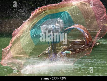 Lancia la rete da pesca al lago di Pedu situato nello stato di Kedah in Malesia Foto Stock