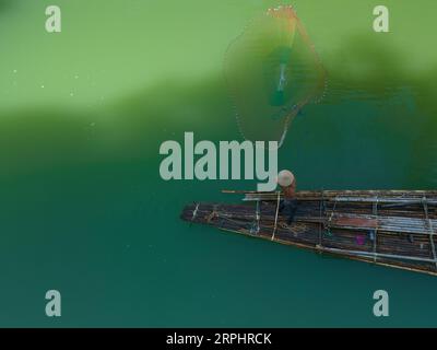 Gli uomini lanciano reti da pesca al lago di Pedu Foto Stock