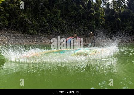 Lancia la rete da pesca al lago di Pedu situato nello stato di Kedah in Malesia Foto Stock