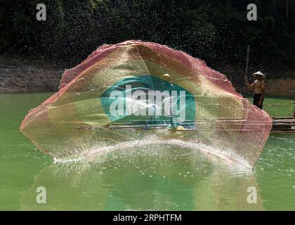 Lancia la rete da pesca al lago di Pedu situato nello stato di Kedah in Malesia Foto Stock